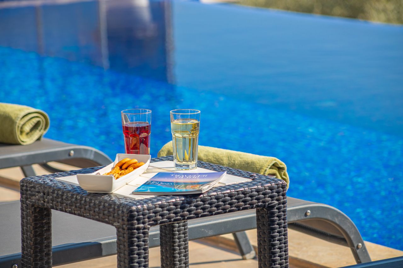 Enjoy a relaxing day by the pool with cold drinks and snacks on a sunny summer afternoon.