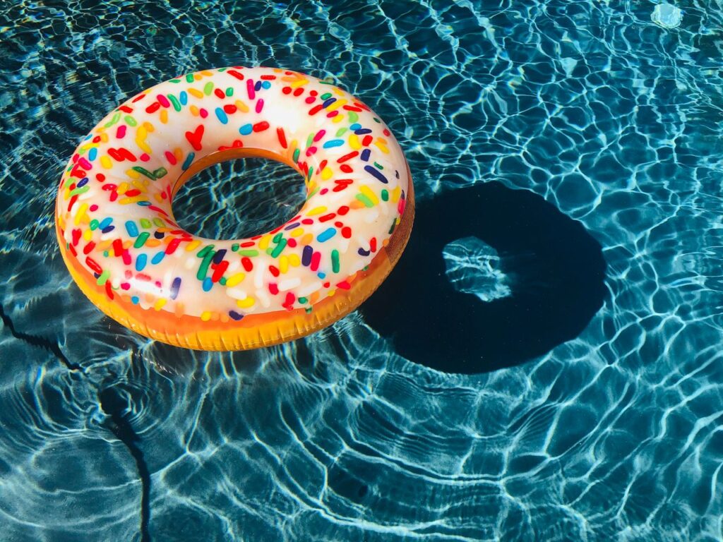 Crafting Captivating Headlines: Your awesome post title goes here A vibrant donut-shaped pool float with sprinkles floating in a sunny swimming pool.